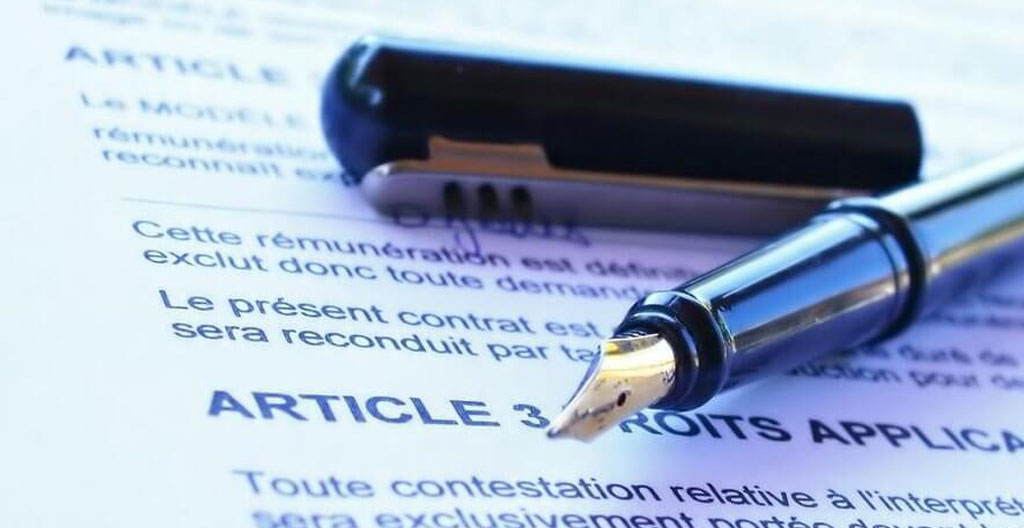 Professionnelle vérifiant les mentions obligatoires sur une facture affichée à l'écran de son logiciel de facturation